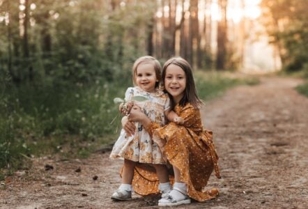 Two cute sisters having fun in the summer park