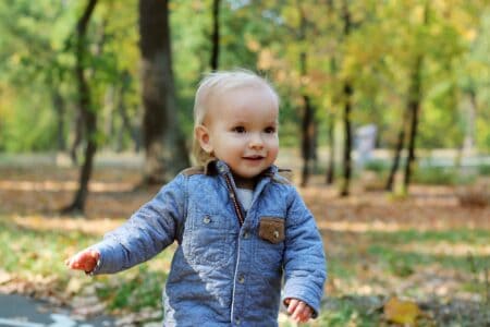 Cute little blond girl walking in the autumn park