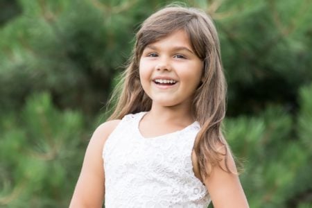 Smiling beautiful young girl with long hair outdoors