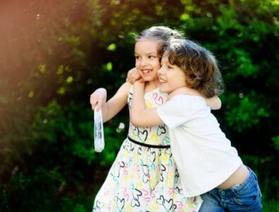 Happy little boy and girl playing in the park