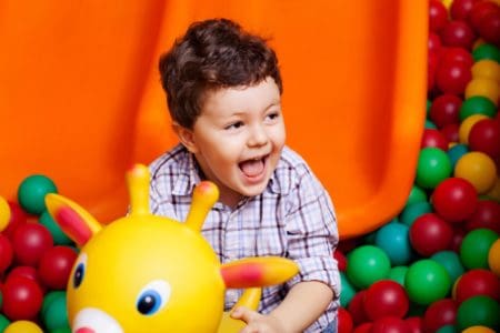 Happy little boy playing with toys