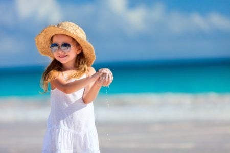 Cute Australian girl playing with sand on the beach