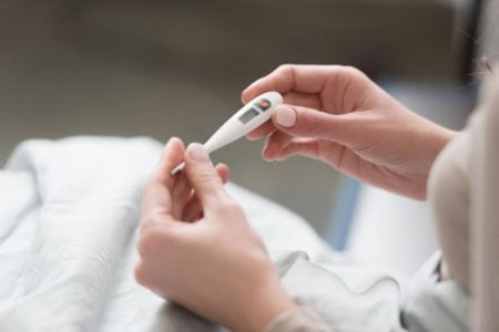 woman holding a thermometer