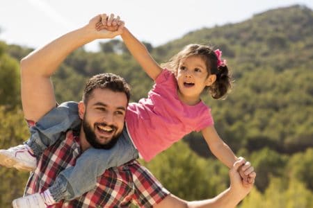 Happy Turkish girl playing with her father in the park.