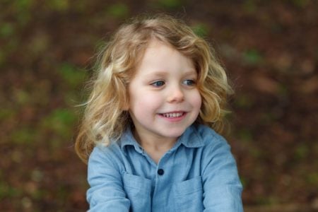 Happy little blond girl spending time in nature