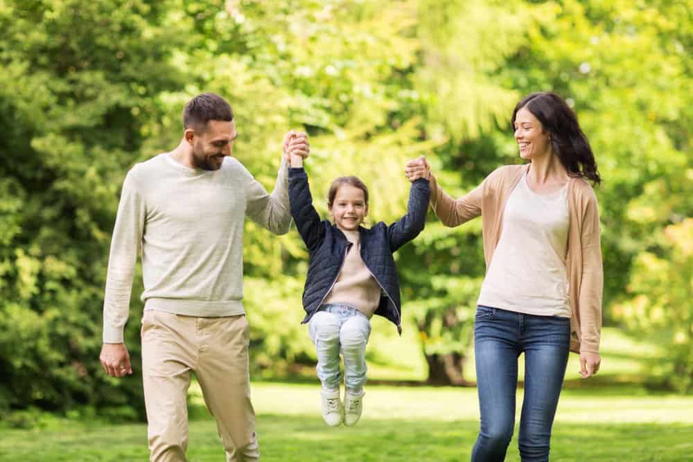 Happy family walking through the park