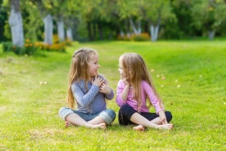 Two cute blonde girls playing in the par