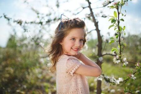 Beautiful little girl playing in the woods