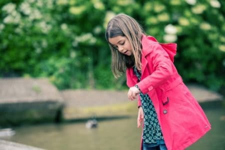 Beautiful little girl playing at the water's edge