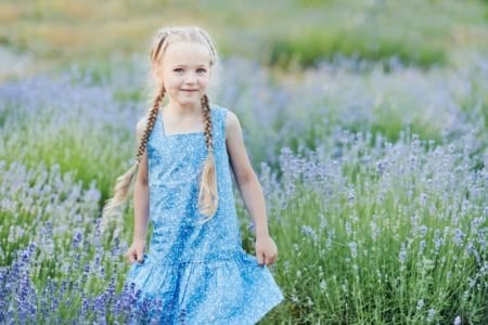 Adorable little girl wearing blue dress in lavender field