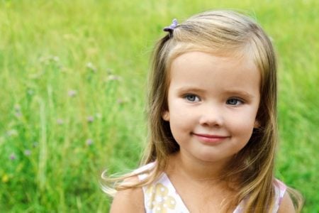 Cute little girl playing in the meadow