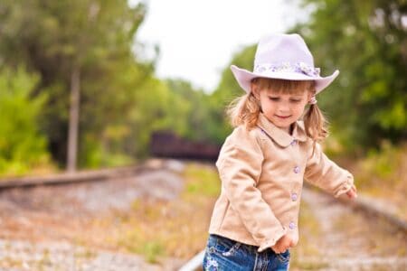 Cute girl in a hat playing outdoors