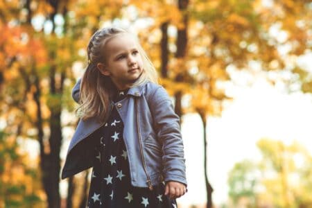 Cute little girl playing in the autumn park