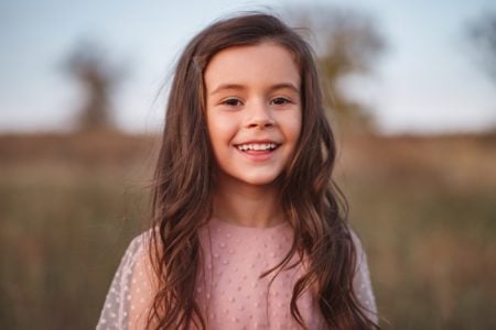 Smiling little girl spending autumn day in the countryside