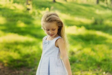 Little girl in white dress playing in the park