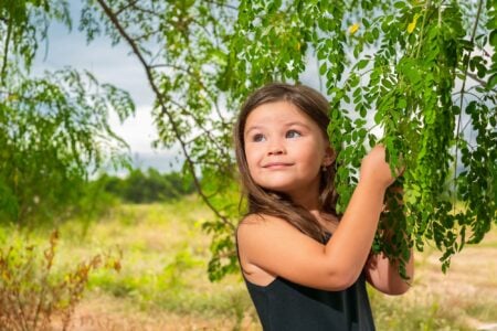 Cute little girl playing under a tree.