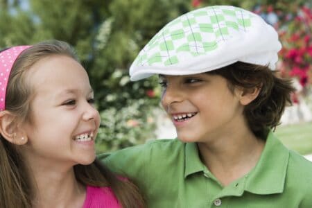 A boy and a girl smiling while looking at each other.