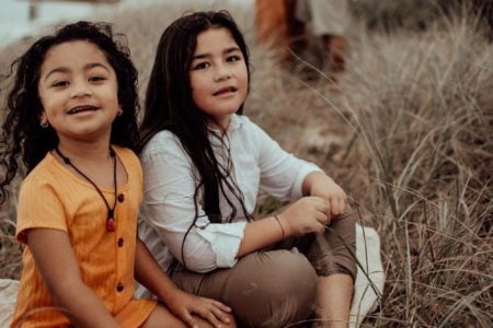 Two little gypsy girls sitting on the grass