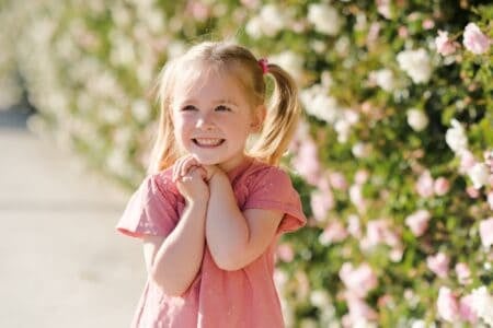 Cheerful pretty girl posing over nature flower background