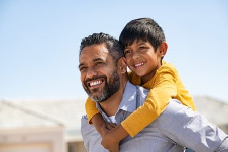 Happy Indian father playing with his son outdoors