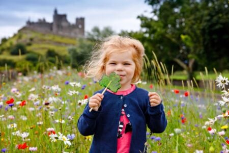 Cute Irish girl holding clover lollipop