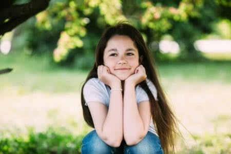 Adorable little young girl posing for the camera in the park