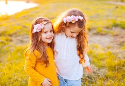 Two girls standing next to each other outdoors