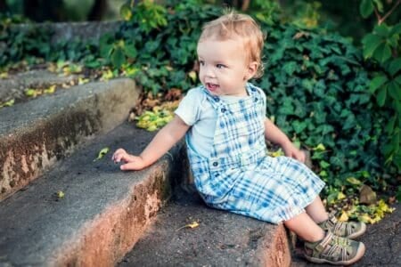 Toddler boy sitting on the stairs in the park