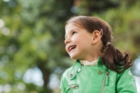 Cheerful beautiful little girl in the park