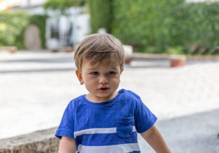 Adorable blonde little boy wearing blue shirt