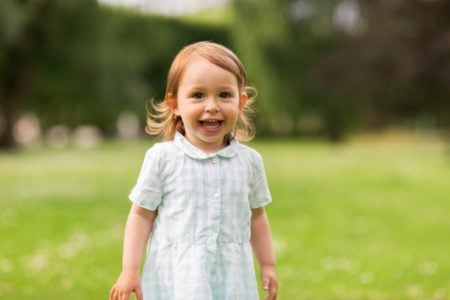 Happy little girl playing in the field