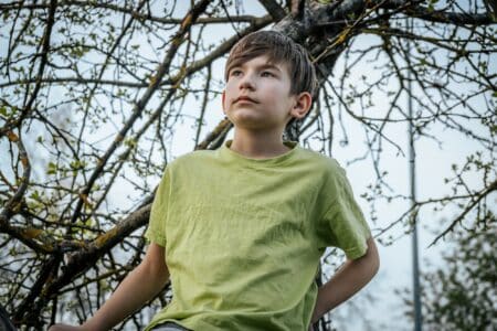 Young boy wearing light green shirt against nature background