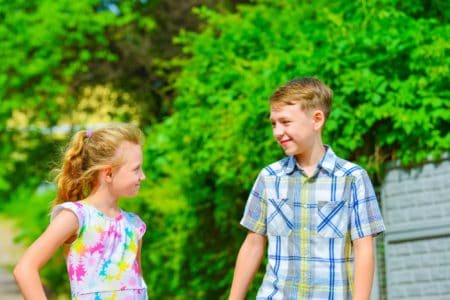 Girl and boy facing each other on the street in the park