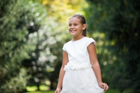 Adorable cheerful little girl smiling in the park