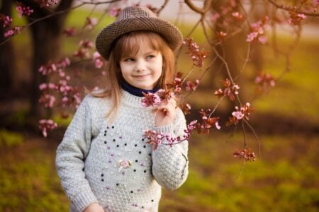 Cute little girl in a hat having fun in the park