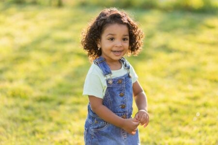 Cheerful little girl in denim having fun outdoors