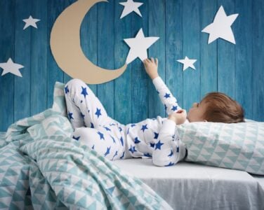 Little boy looking at the star on the wall of his bedroom