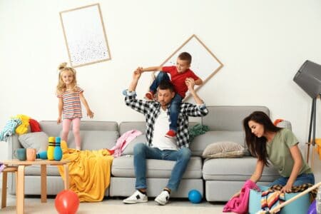 Frustrated parents cleaning up the mess made by their naughty children.