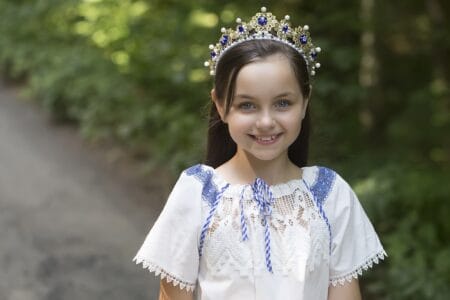 Pretty girl with a big smile wearing crown outdoors