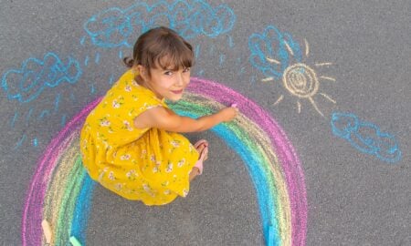 Little girl drawing a rainbow.