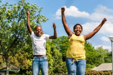 Nigerian kids jumping together in the park