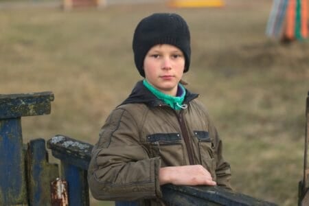 Serious young child with serious face looking straight to the camera