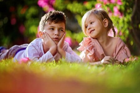 A boy and a girl lying on the grass