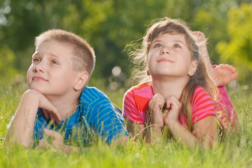 A boy and a girl lying on the grass in the park