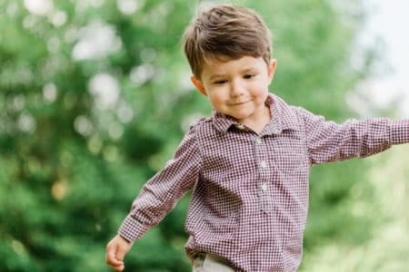 Adorable cheerful cute little boy having fun in park