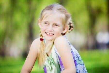 Happy little girl sitting in the park.