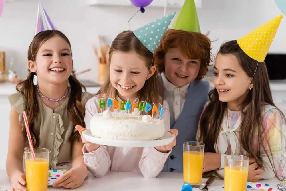 Happy girl celebrating her 11th birthday with friends.