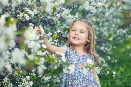 Happy little girl playing in the garden.