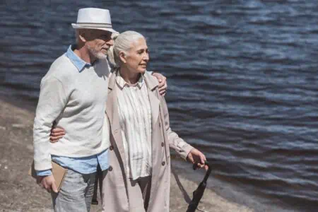 Boomer couple strolling near the beach