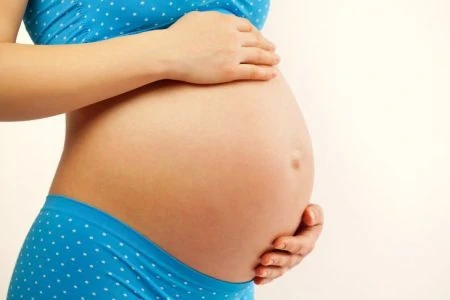 Pregnant woman holding her bare belly